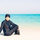 Young-woman-wearing-burkini-sitting-by-the-beach-in-dubai